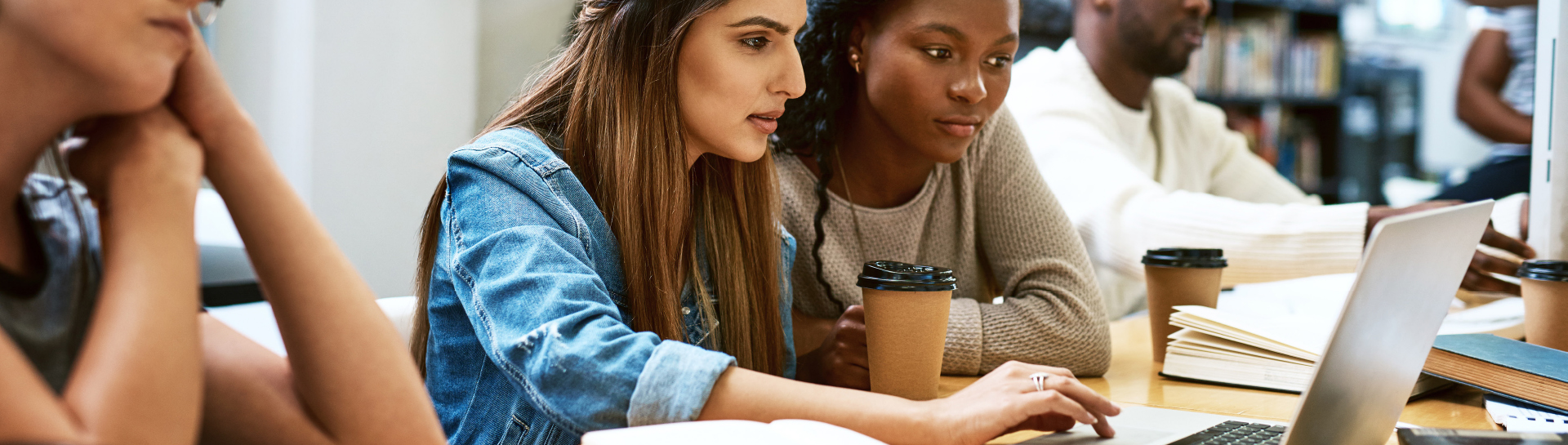 college girls researching on a laptop in the library